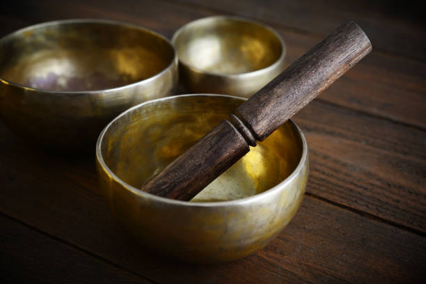 Tibetan handcrafted singing bowls with sticks on wooden background